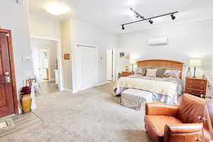 Casita - Bedroom featuring light carpet, a wall mounted air conditioner, and a closet