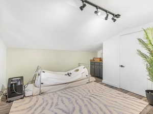 Bedroom with lofted ceiling and light hardwood / wood-style floors