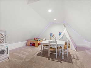 Recreation room featuring lofted ceiling and carpet flooring