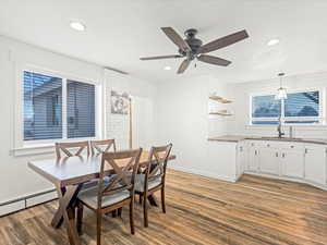 Dining area featuring sink, wood-type flooring, and ceiling fan