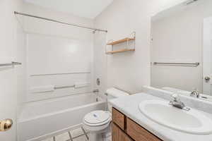 Full bathroom with bathtub / shower combination, vanity, toilet, and tile patterned flooring