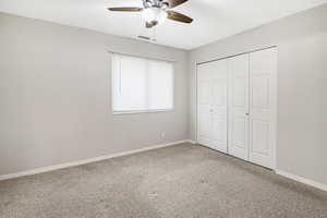 Unfurnished bedroom with a closet, ceiling fan, and carpet flooring