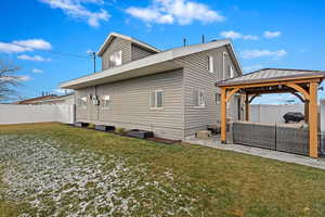 Back of property featuring a gazebo, outdoor lounge area, a patio area, and a lawn