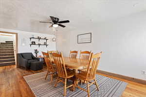 Dining room featuring hardwood / wood-style flooring, ceiling fan, and a textured ceiling