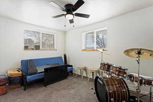 Living area with carpet floors and ceiling fan