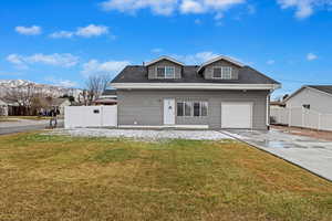 View of front of house with a garage and a front lawn