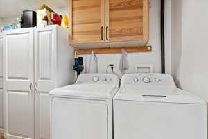 Washroom featuring washer and dryer and cabinets