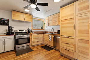 Kitchen with appliances with stainless steel finishes, sink, light brown cabinets, and light hardwood / wood-style floors