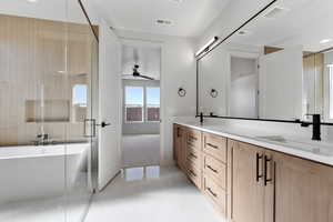 Bathroom featuring vanity, ceiling fan, and plus walk in shower