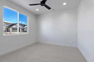 Carpeted spare room featuring ceiling fan