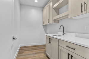 Laundry room featuring sink and light hardwood / wood-style floors