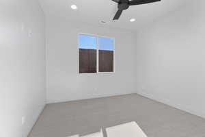 Carpeted empty room featuring ceiling fan