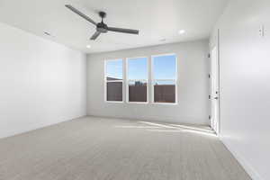 Unfurnished room featuring light carpet and ceiling fan