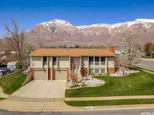 Split foyer home with a front yard, brick siding, and a mountain view