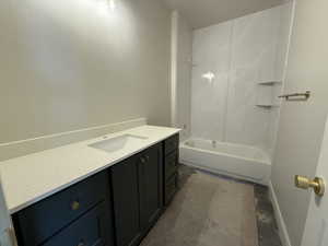Bathroom with baseboards, washtub / shower combination, and vanity