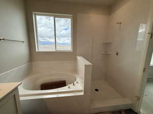 Bathroom with vanity, walk in shower, and a bath