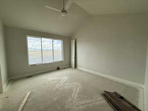 Unfurnished room with ceiling fan, vaulted ceiling, and baseboards