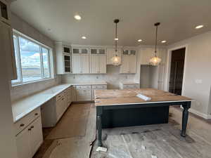 Kitchen featuring recessed lighting, glass insert cabinets, and tasteful backsplash