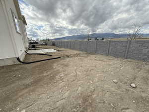 View of yard featuring a mountain view and fence