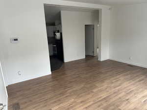 Empty room with dark wood-type flooring