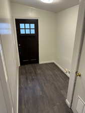 Foyer entrance with dark wood-type flooring and a textured ceiling