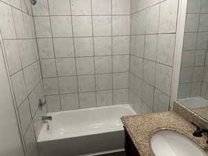 Bathroom featuring vanity and tiled shower / bath