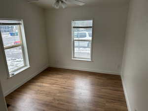 Empty room with dark wood-type flooring and ceiling fan