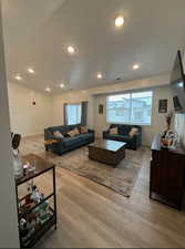 Living room featuring light hardwood / wood-style floors and a textured ceiling