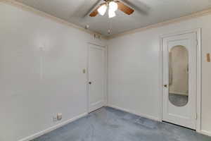 Carpeted spare room with ceiling fan and a textured ceiling