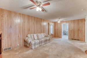 Unfurnished living room with a textured ceiling and wood walls