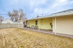 Rear view of house with a yard and a patio