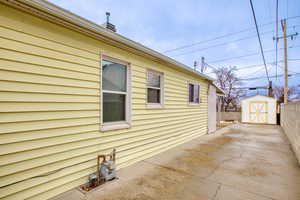 View of home's exterior featuring a storage shed and a patio area