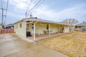 View of front of home featuring a patio, a front yard, and cooling unit