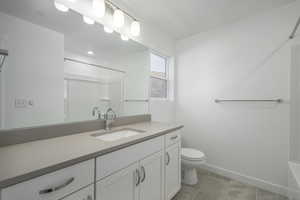 Bathroom featuring vanity, tile patterned flooring, and toilet