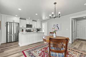 Dining room featuring an inviting chandelier, sink, and light wood-type flooring