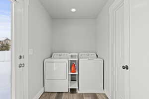 Washroom featuring separate washer and dryer and hardwood / wood-style floors