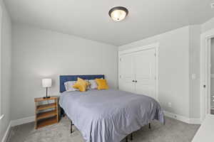 Bedroom with light colored carpet and a closet