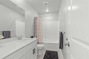 Full bathroom featuring vanity, toilet, tile patterned flooring, and shower / bath combo with shower curtain