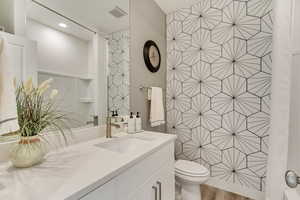 Bathroom featuring vanity, wood-type flooring, and toilet