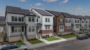 View of property with a front lawn and central air condition unit