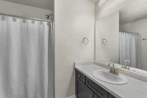 Bathroom with vanity and a shower with shower curtain