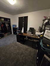 Carpeted office space featuring a textured ceiling