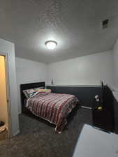 Carpeted bedroom featuring a textured ceiling