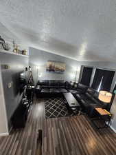 Living room featuring dark wood-style floors and a textured ceiling