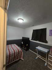 Carpeted bedroom with a textured ceiling