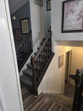 Staircase featuring wood-style floors