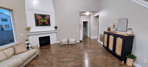 Living room with a towering ceiling and dark hardwood / wood-style floors