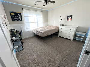 Carpeted bedroom featuring ceiling fan