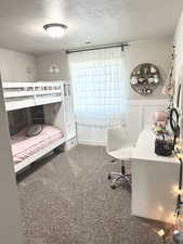 Carpeted bedroom featuring a textured ceiling