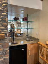 Wet Bar featuring stone, granite counters and sink